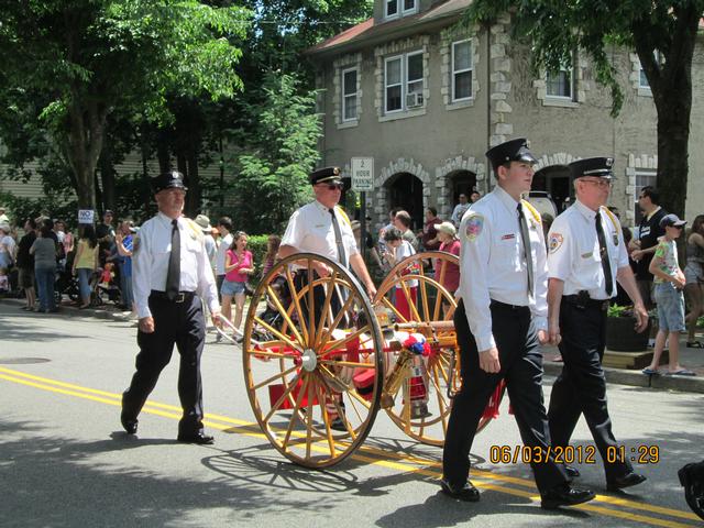 Harmon Engine members pulling the &quot;Yesterday's Fires&quot; hose cart at the 2012 Summerfest Parade. 